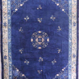 Royal blue rug featuring scattered floral motifs and a detailed beige and light blue border.