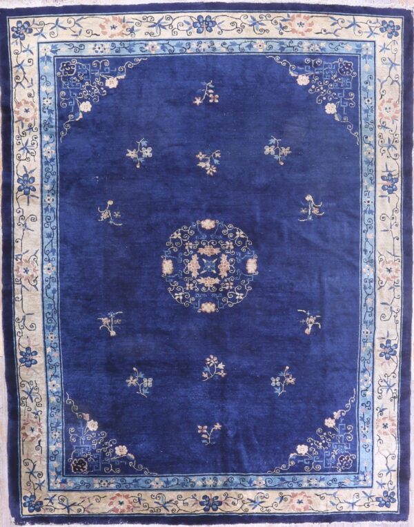 Royal blue rug featuring scattered floral motifs and a detailed beige and light blue border.