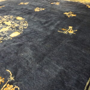 Plush dark blue rug with scattered gold floral motifs and a detailed green and gold border.