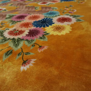 Close-up of a plush mustard rug with a colorful floral and foliage bouquet pattern.