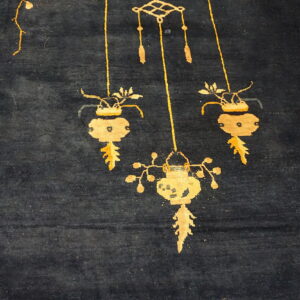 A dark blue, high-pile rug displays golden yellow stylized hanging lantern and vase patterns.