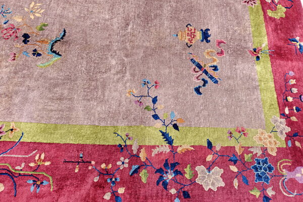 Mauve, magenta, and green rug featuring colorful scattered floral motifs and detailed borders.