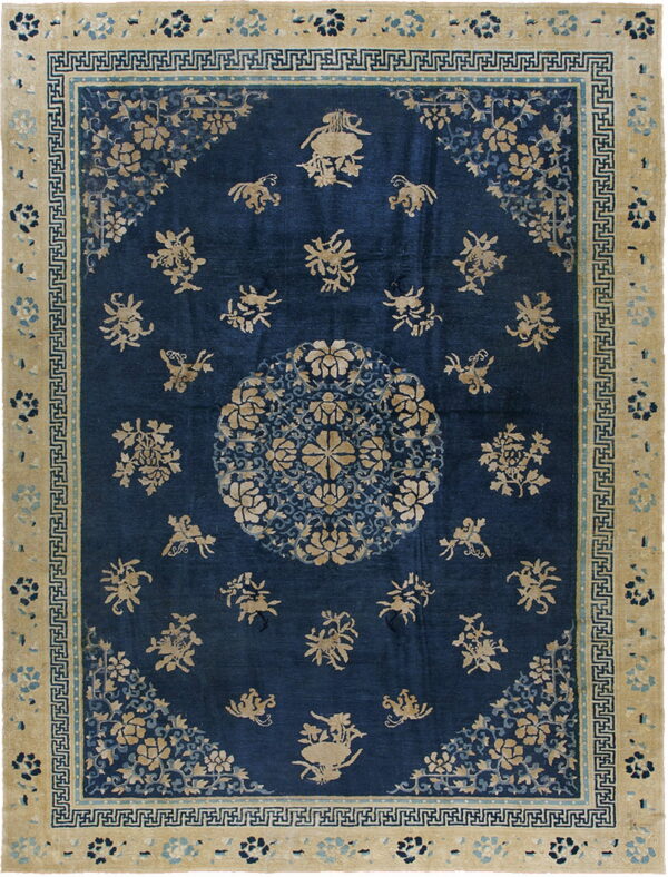 Navy blue rug with tan floral and animal figures, a central medallion, and a wide beige key-pattern border.