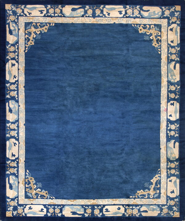 Solid blue rug featuring a wide border with intricate cream floral, fretwork, and landscape vignettes.
