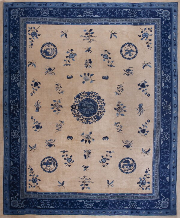 Tan field rug featuring scattered blue floral motifs, a central medallion, and elaborate triple blue borders.