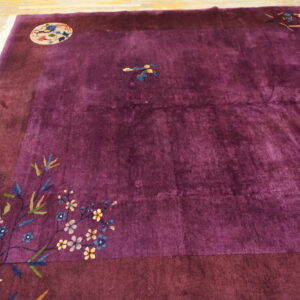 Plush purple rug with a wide dark border, colorful floral motifs, and a round bird medallion.