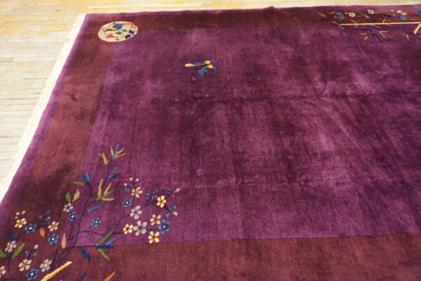 Plush purple rug with a wide dark border, colorful floral motifs, and a round bird medallion.