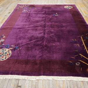 Deep purple rug with a burgundy border and colorful floral and bamboo motifs on wood flooring.