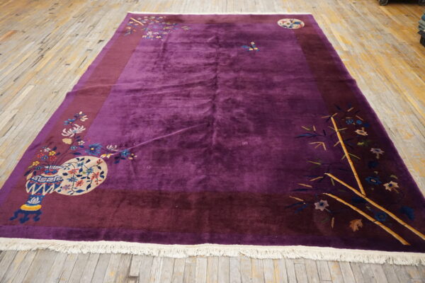 Deep purple rug with a burgundy border and colorful floral and bamboo motifs on wood flooring.