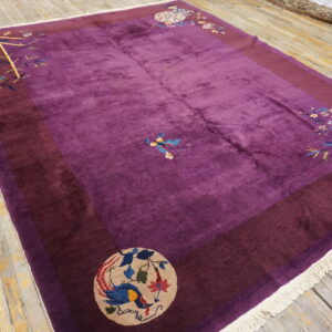 Deep purple high-pile rug with maroon border and colorful floral medallions on worn wooden flooring.