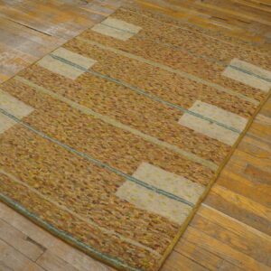 Textured gold and orange striped rug with horizontal cream rectangles lies on worn wood floors.