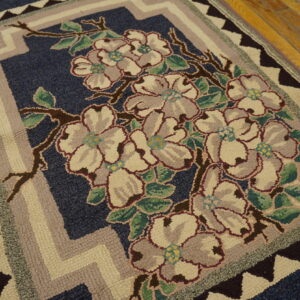 A high-texture rug featuring cream and gray flowers on navy blue, with zigzag borders on wood planks.
