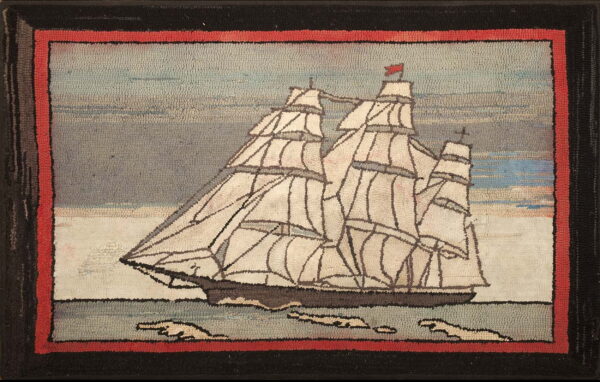 Hooked nautical rug showing a white-sailed ship on the water, framed by red and black pile borders.