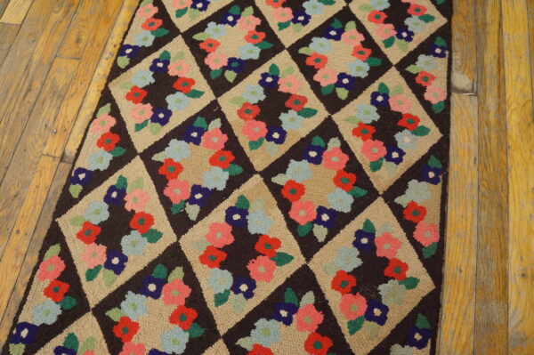 A dark brown and tan diamond rug with multicolored floral clusters lies on distressed wood floors.