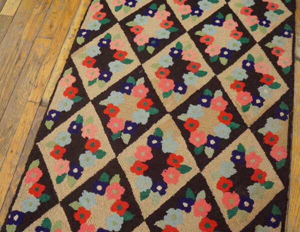 Textured rug runner on wood floor features colorful floral clusters inside dark brown and tan diamonds.
