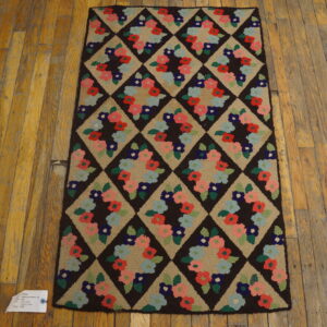 Runner rug with a dark brown diamond lattice enclosing multicolored floral wreaths on a distressed wood plank floor.