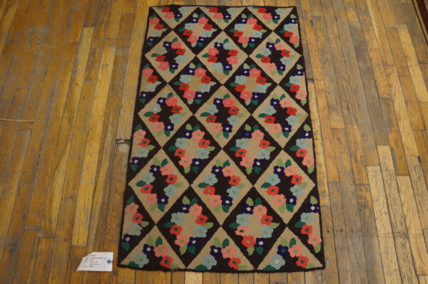 Runner rug with a dark brown diamond lattice enclosing multicolored floral wreaths on a distressed wood plank floor.