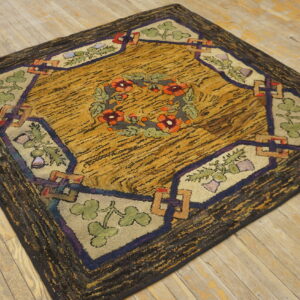 Highly textured rug with a mustard yellow field, dark border, and floral wreath pattern on light wood floorboards.
