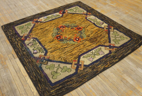 Highly textured rug with a mustard yellow field, dark border, and floral wreath pattern on light wood floorboards.
