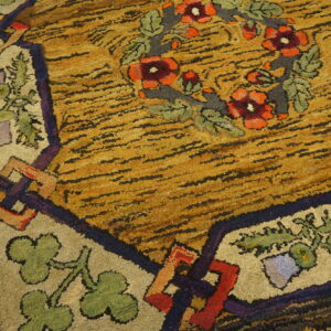 A highly textured shaggy rug features a gold and black striped field with a colorful floral border design.