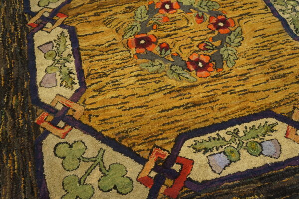 A highly textured shaggy rug features a gold and black striped field with a colorful floral border design.