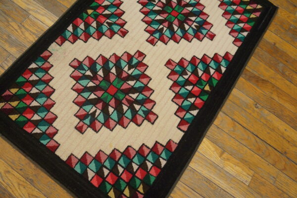 Multicolored geometric rug featuring red, teal, and green diamond starbursts on a cream field.