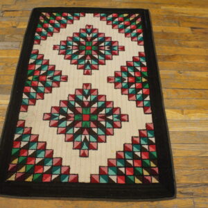 A colorful geometric runner rug featuring diamond patterns on a cream field, lying on distressed hardwood.