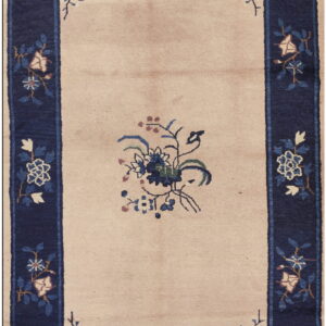 Beige rug featuring a navy blue botanical border and blue, green, and pink flowers in the field.