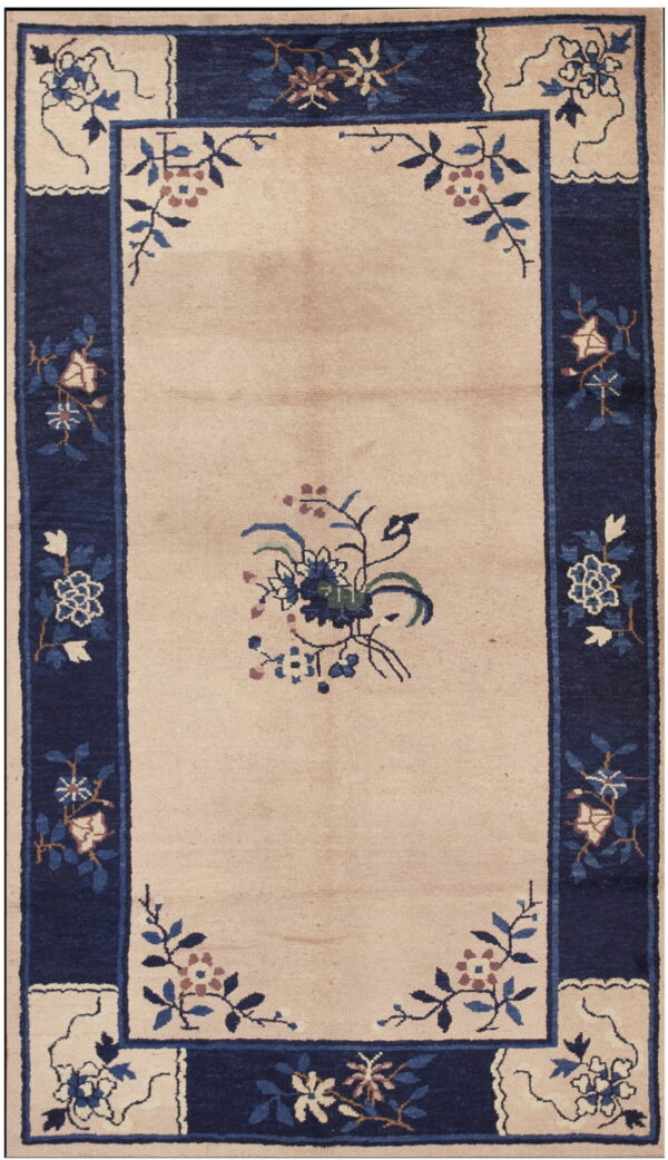 Beige rug featuring a navy blue botanical border and blue, green, and pink flowers in the field.