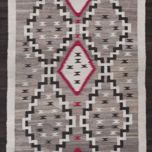 Gray flatweave rug with black, white, and red geometric stepped diamonds on a variegated field.