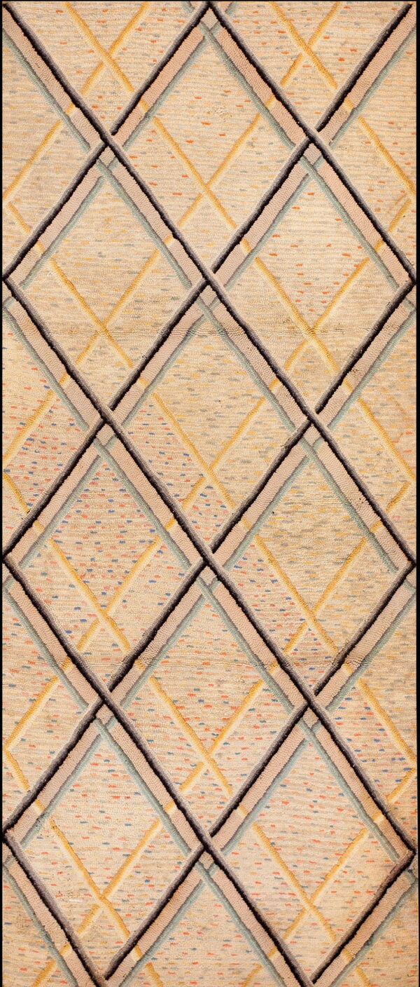 A cream textured rug featuring a dimensional, interlocking diamond pattern in black, gray, taupe, and blue.