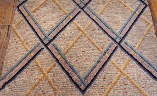 Raised diamond pattern rug in textured beige, gold, pale blue, and dark gray on wood floor.