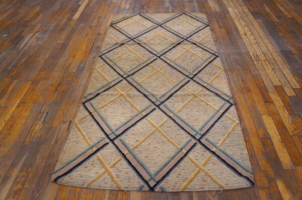 Textured beige runner with geometric diamonds outlined in blue, black, and gold on wood planks.