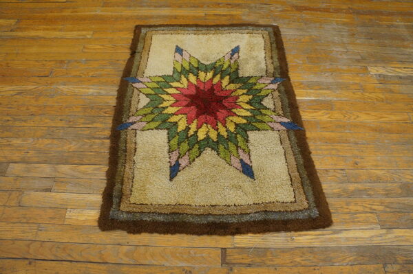 A high-pile rug with a vibrant star medallion and brown borders lies on yellow wooden floors.