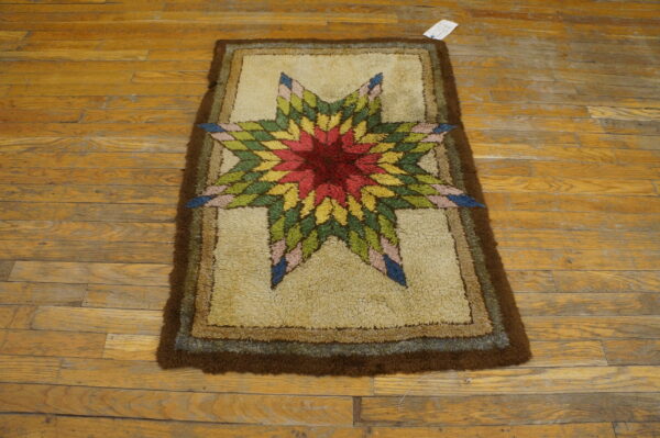 Shaggy rug featuring a bright, multicolored starburst pattern against a tan field on a worn wooden floor.