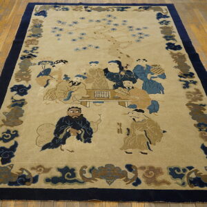 Light beige rug with blue and tan figures, surrounded by a dark navy border on wood flooring.