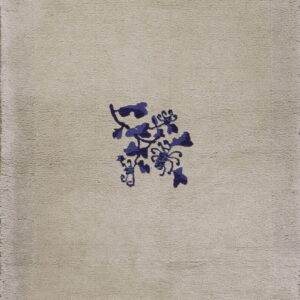 Beige medium-pile rug featuring scattered indigo floral and leaf motifs with a subtle inner border.