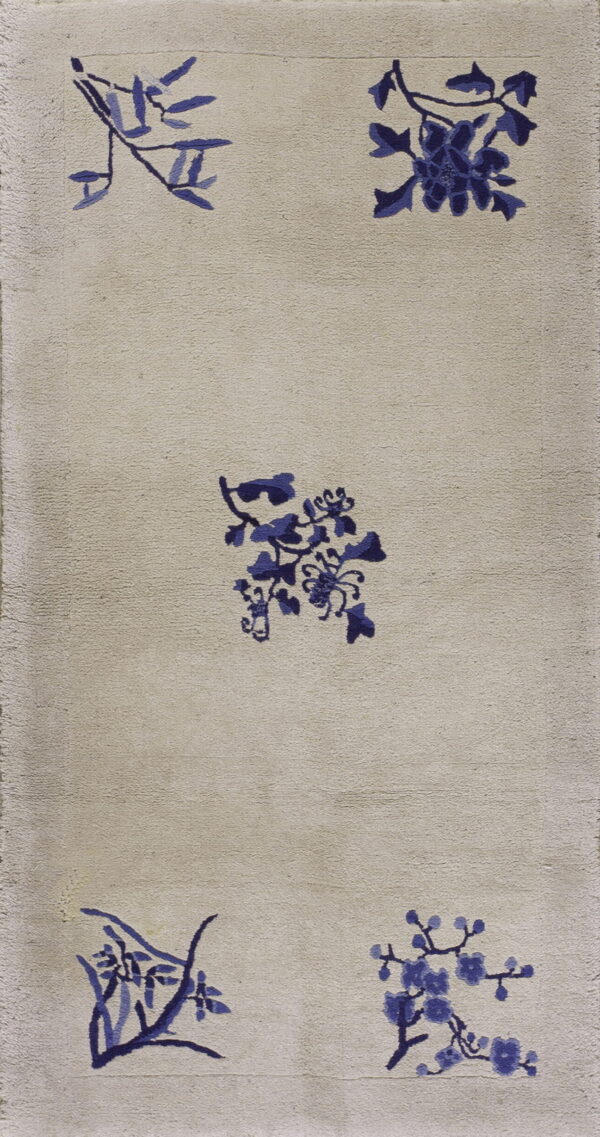 Beige medium-pile rug featuring scattered indigo floral and leaf motifs with a subtle inner border.