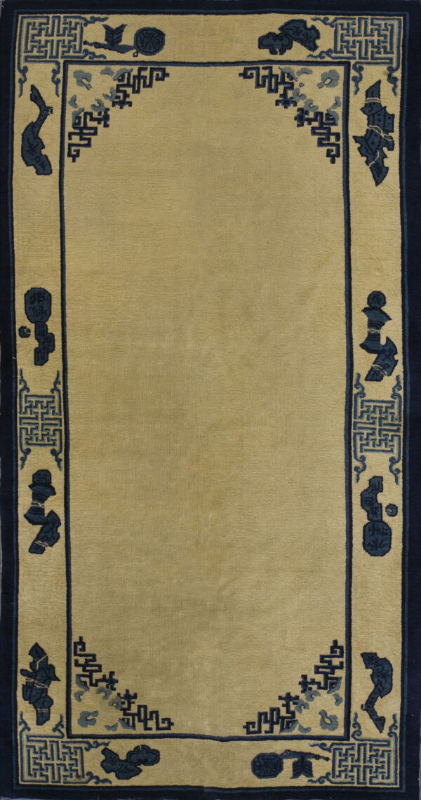 Solid beige field rug framed by an intricate dark blue border with symbols and key patterns.