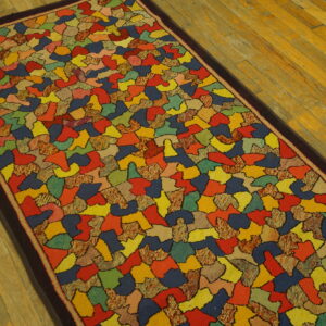 Vibrant runner rug with an abstract mosaic pattern outlined in black, set on warm-toned wood flooring.