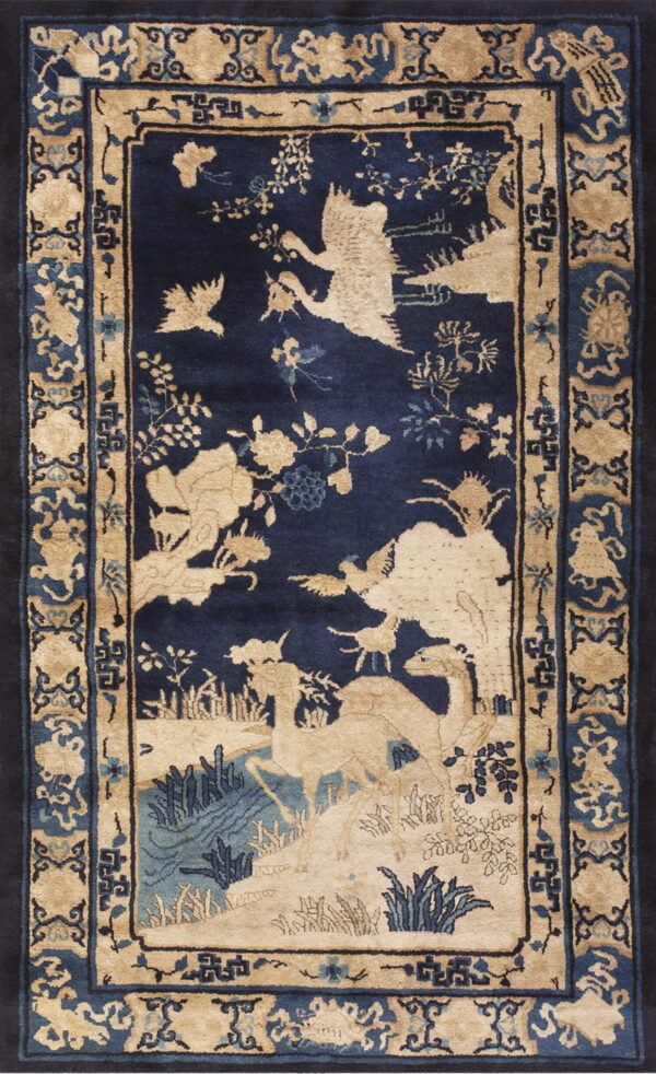 Navy blue rug with a beige wildlife scene centerpiece and complex blue and tan decorative borders.