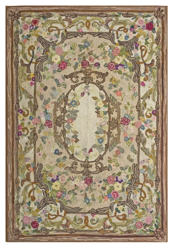 Textured hooked rug featuring a beige field, ornate brown scrollwork, and dense multicolored floral motifs throughout.