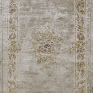 Lustrous beige rug with tone-on-tone sculptured floral borders and a detailed central medallion.