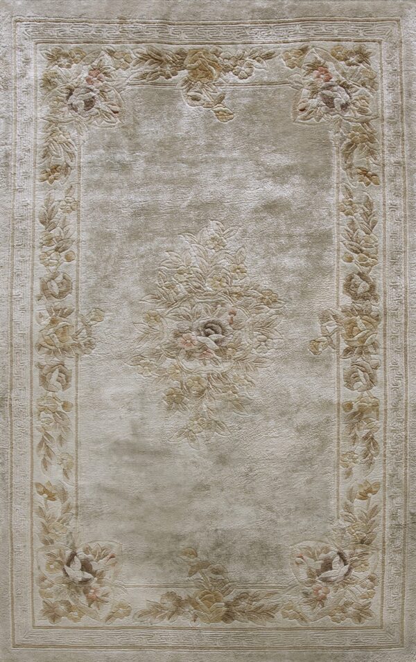 Lustrous beige rug with tone-on-tone sculptured floral borders and a detailed central medallion.