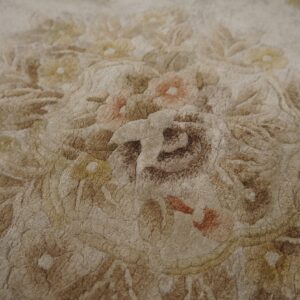 Plush beige and brown rug featuring a heavily textured floral pattern with rust and gold accents.