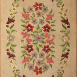 Hooked beige rug featuring a colorful central floral spray surrounded by a detailed, multi-colored oval wreath border.