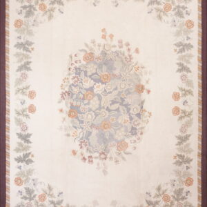 Cream rug featuring pastel floral vines and a center medallion surrounded by a dark purple border.