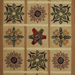 Rustic hooked rug featuring a grid design with alternating red, teal, gold, and green floral patterns on tan.