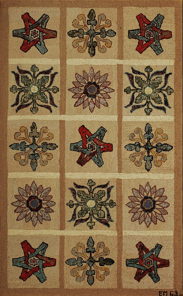 Rustic hooked rug featuring a grid design with alternating red, teal, gold, and green floral patterns on tan.