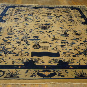 Tan rug with detailed indigo Chinese floral and vase patterns on wide plank wood floors.